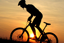 Radfahrer bergauf in der Abendsonne